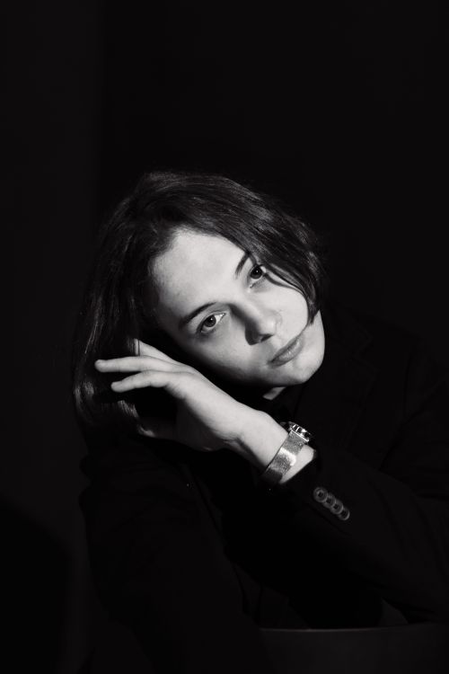 Free Stunning black and white studio portrait featuring a stylish young adult in a blazer and wristwatch. Stock Photo
