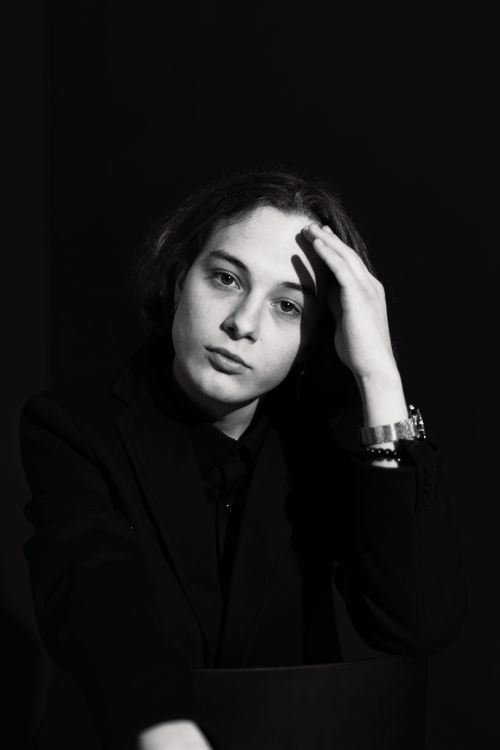 Free Elegant black and white portrait of a young adult in a blazer posing with a wristwatch. Stock Photo