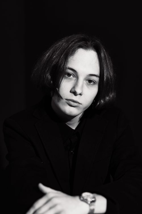 Free A striking black and white portrait of a woman wearing a wristwatch, highlighting her thoughtful expression. Stock Photo