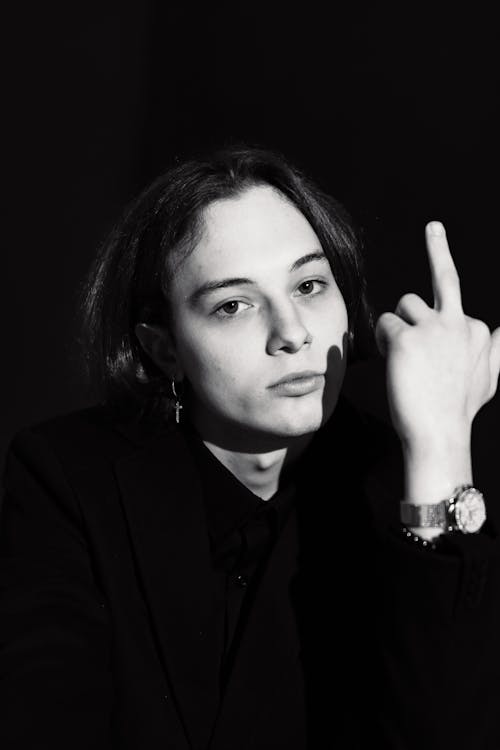 Black and White Photo of a Young Person Showing the Middle Finger 