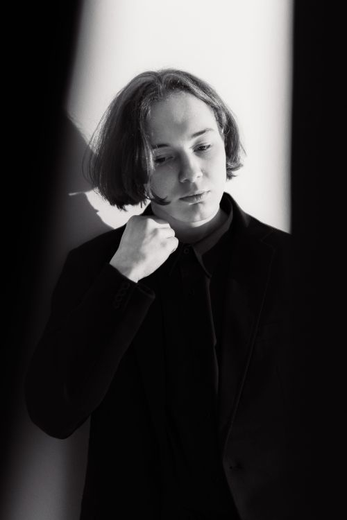Free A stylish black and white portrait of a person posing thoughtfully in a studio setting. Stock Photo