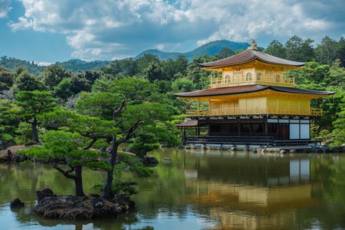 Free Scenic view of Kinkaku-ji Temple in Kyoto, reflecting in a tranquil pond surrounded by trees. Stock Photo