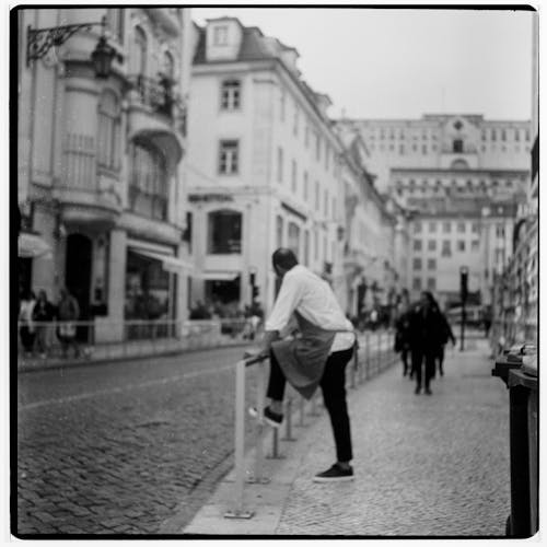 Black and White Photo of a Street between Buildings in City 