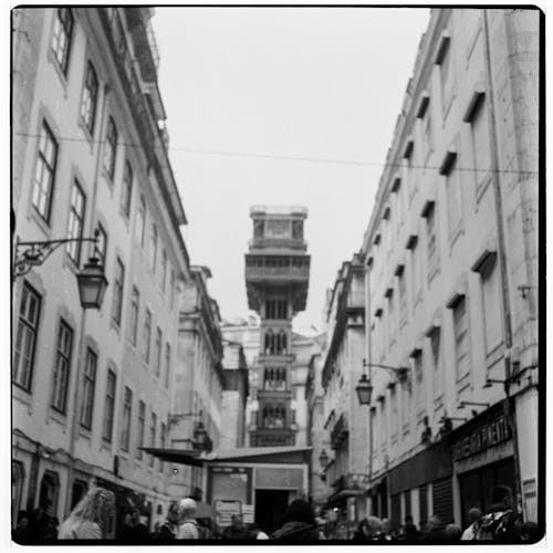 Black and White Film Photo of a Street with View of the Santa Justa Lift in Lisbon, Portugal