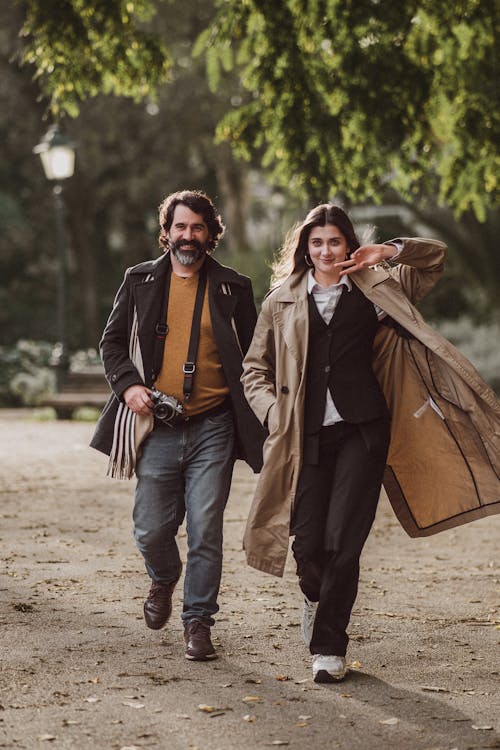 A Man and Woman Walking in a Park and Smiling 