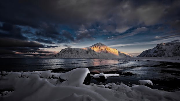 Stunning winter landscape at Napp, Nordland with snowy mountains and dramatic sunset.