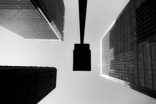 Black and white view from below of towering skyscrapers creating a modern urban pattern.