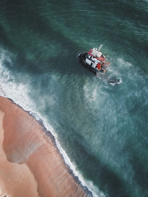 Free Drone view of a sunken ship near the sandy coast of Chukai, Terengganu, Malaysia. Stock Photo