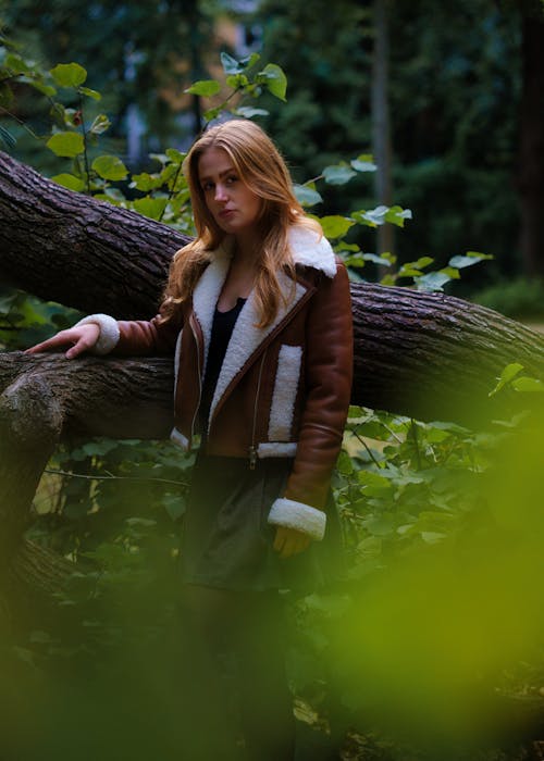 Young Woman in a Leather Jacket Standing in the Forest
