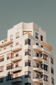 Elegant corner of a modern apartment building against a clear blue sky.