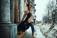 一位穿着时髦的时尚女性，在白雪皑皑的城市街道上自信地摆着姿势