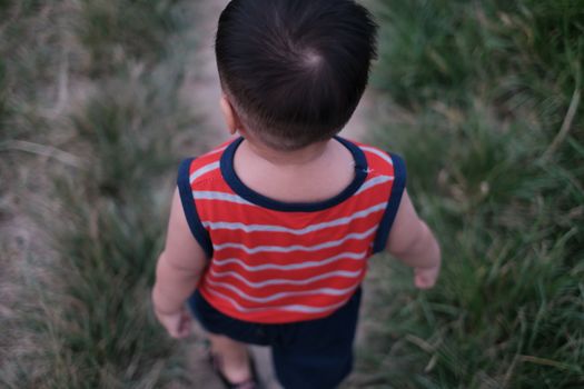 A child walking down a path in the grass