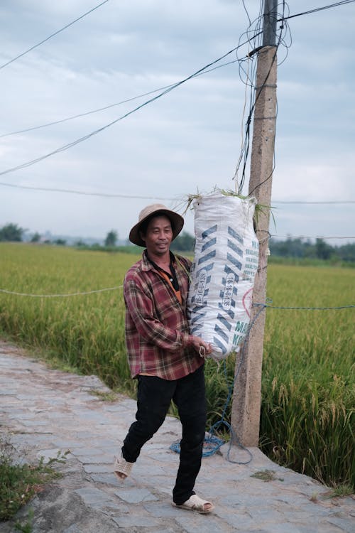 Farmer Carrying Bag near Field