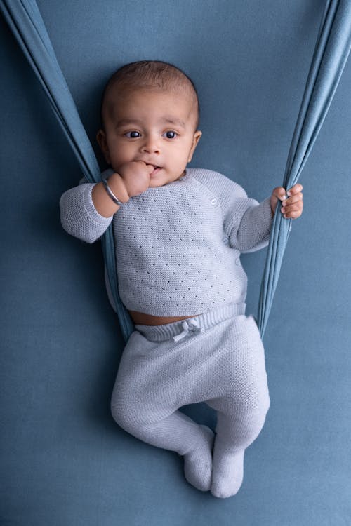 A baby is laying on a blue blanket