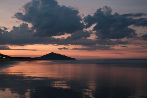 Free Calm seascape with colorful sunset reflection and dramatic clouds. Stock Photo