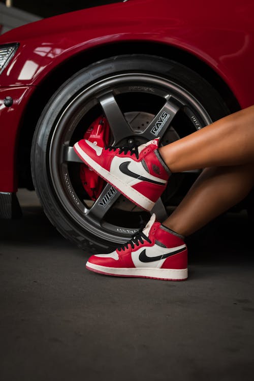 Woman Legs in Shoes near Tuned Car Wheel