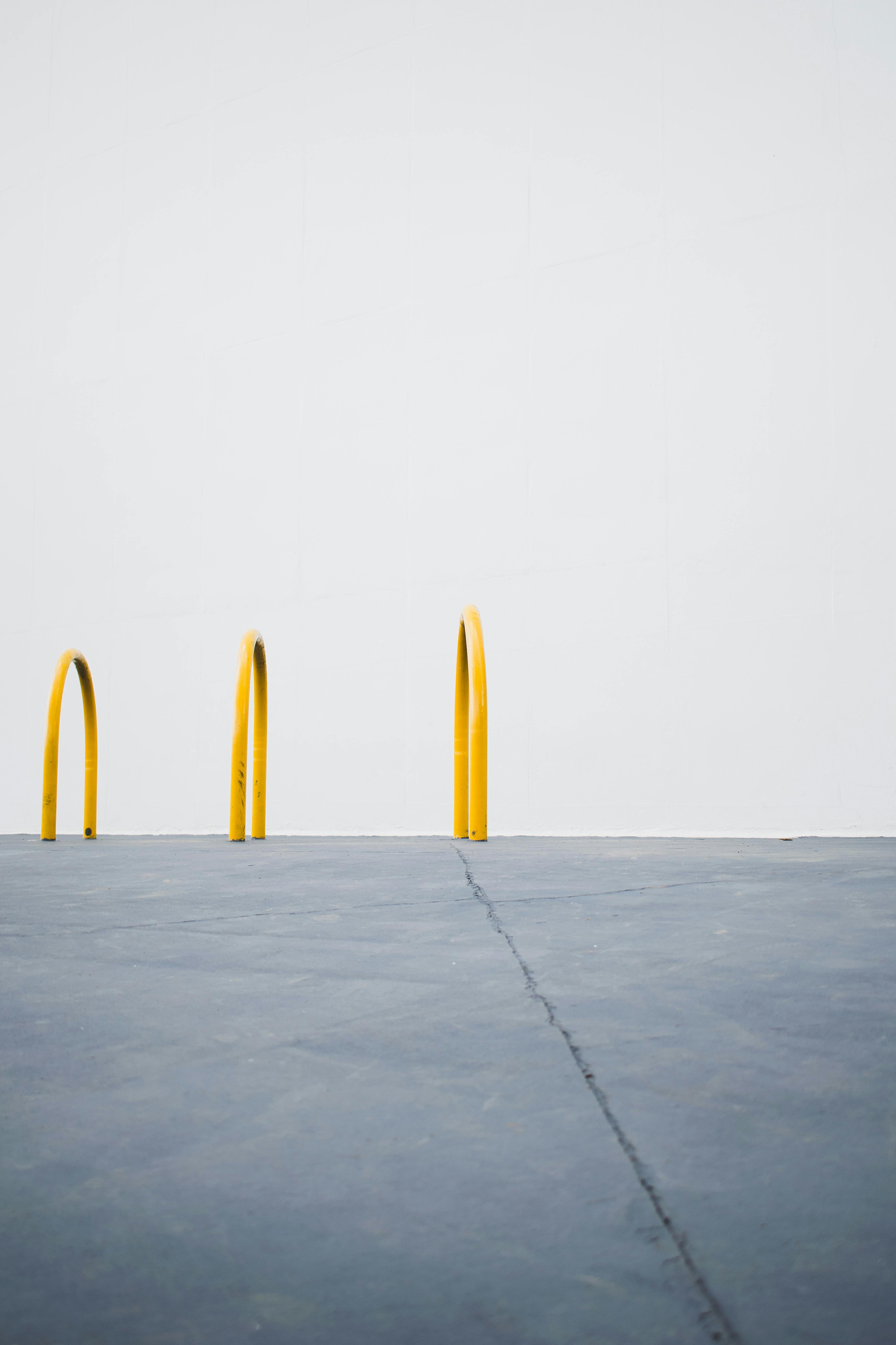 中性背景下，一个简约的城市场景与三个黄色自行车架相对