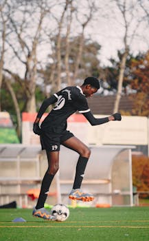 Athlete in athletic gear practicing on football field in Berlin during fall.