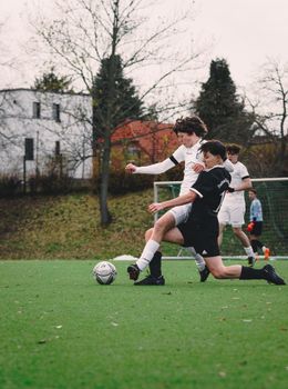 Players committed in a competitive soccer game on an outdoor field in Berlin.