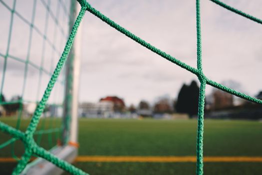 Focused close-up of a soccer goal net with field view, taken in Berlin, Germany.