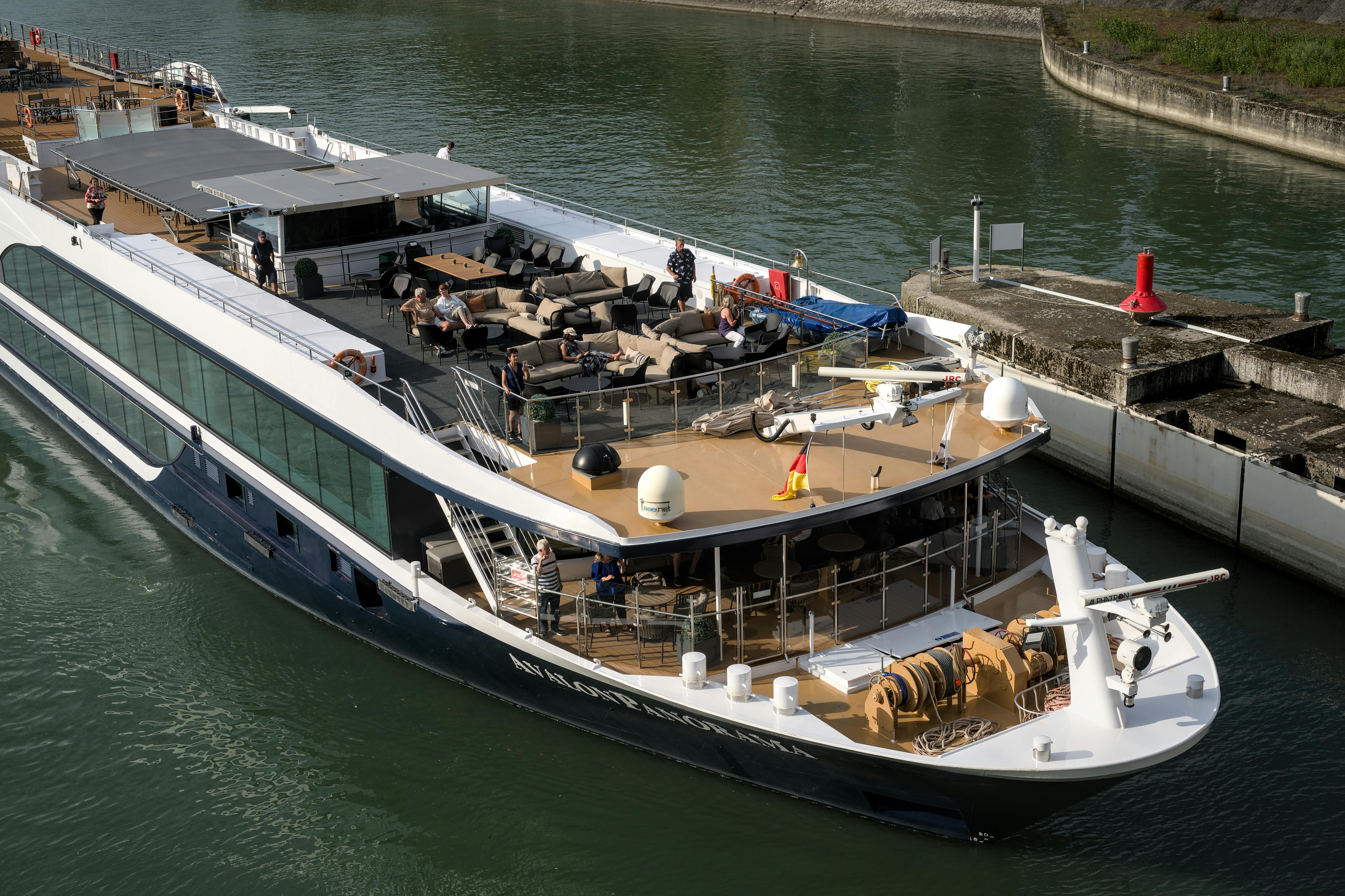 Elegant cruise ship with passengers enjoying sunny day at the port.