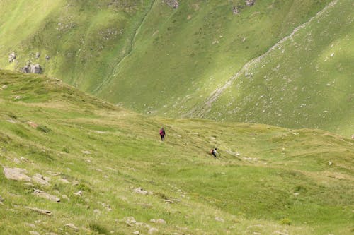 People on Green Hill over Valley in Mountains