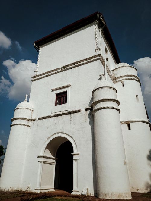 Free A striking white church facade with arches set against a vibrant blue sky. Stock Photo