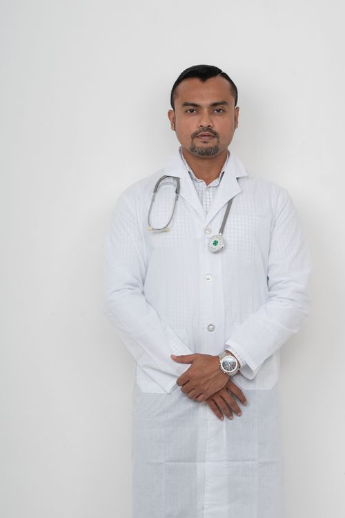 Free A young male doctor in a white coat with a stethoscope, posing confidently indoors. Stock Photo