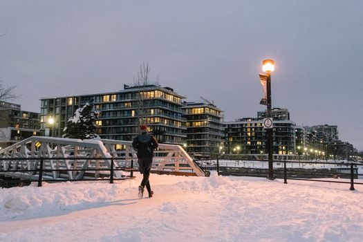 A person walking on the snow covered sidewalk