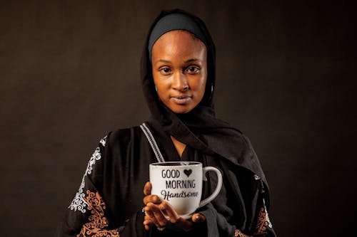 Woman wearing Traditional Clothing Holding Coffee Cup in Hands