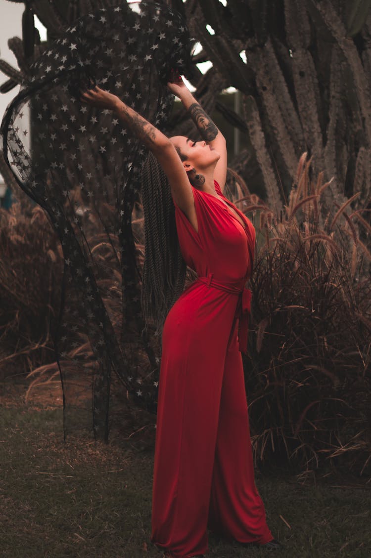 Woman Wearing Red Jumper Standing Near Plants