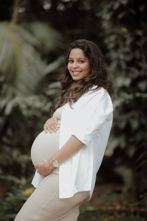 Smiling, Pregnant Woman in White Shirt