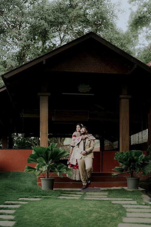 Newlyweds Hugging near Building in Garden