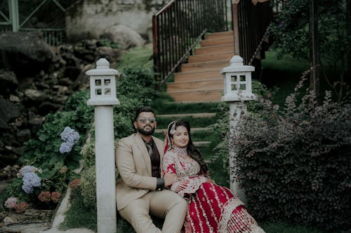 Newlyweds in Suit and Wedding Dress Sitting on Stairs