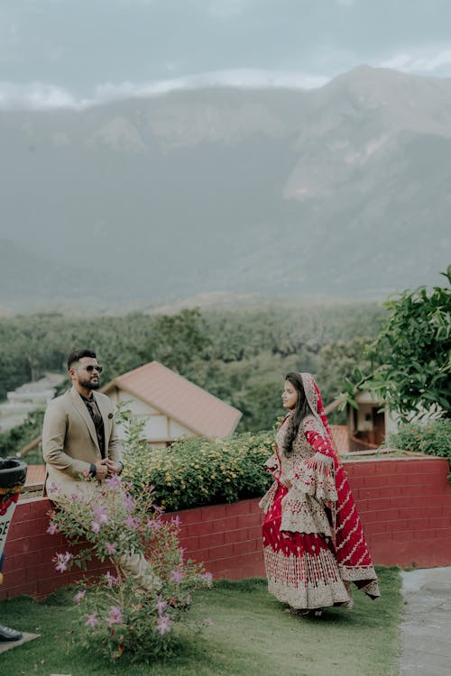 Newlyweds near Wall and Flowers in Village