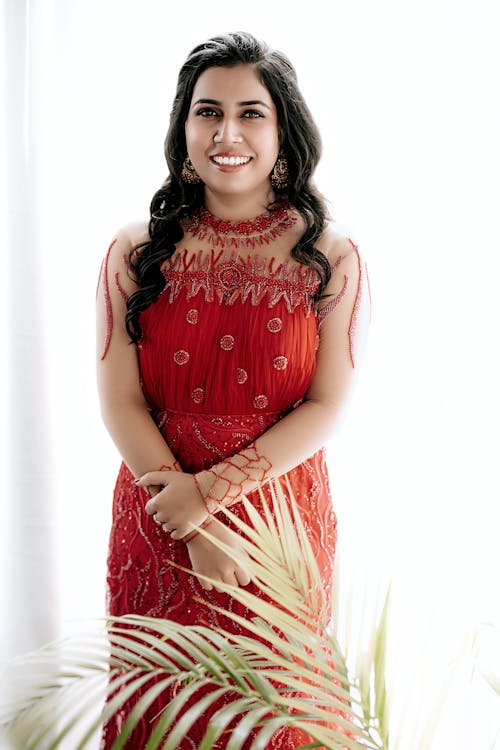 Model in an Elegant Red Dress with Long Embroidered Sleeves