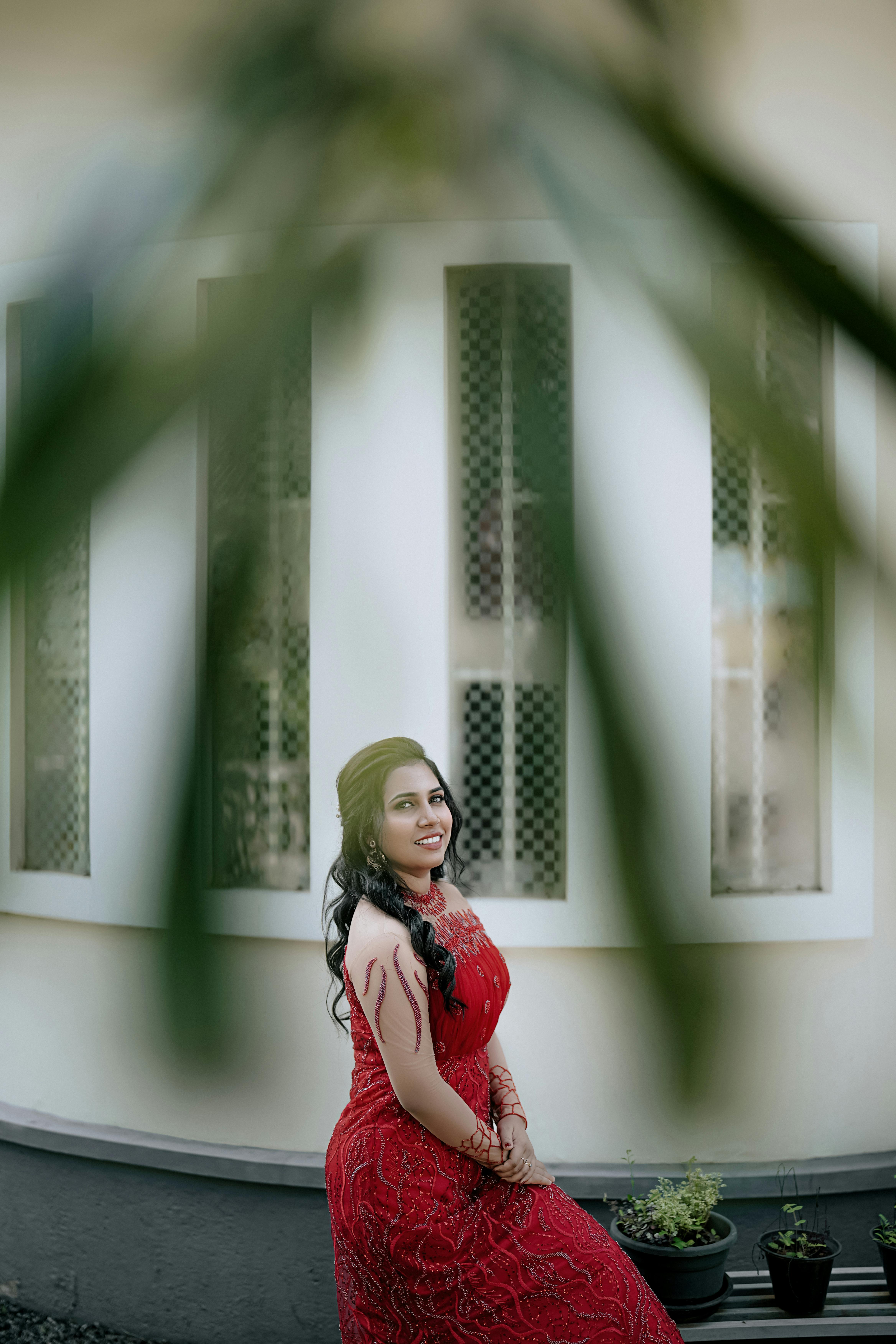 Smiling Model in an Elegant Red Dress Posing Under a Tree Branch · Free  Stock Photo