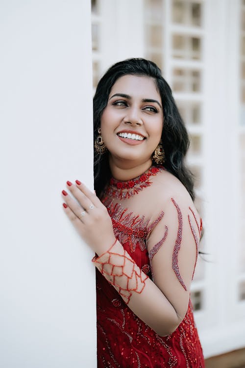 Smiling Young Model in Red Dress by the Corner of the House