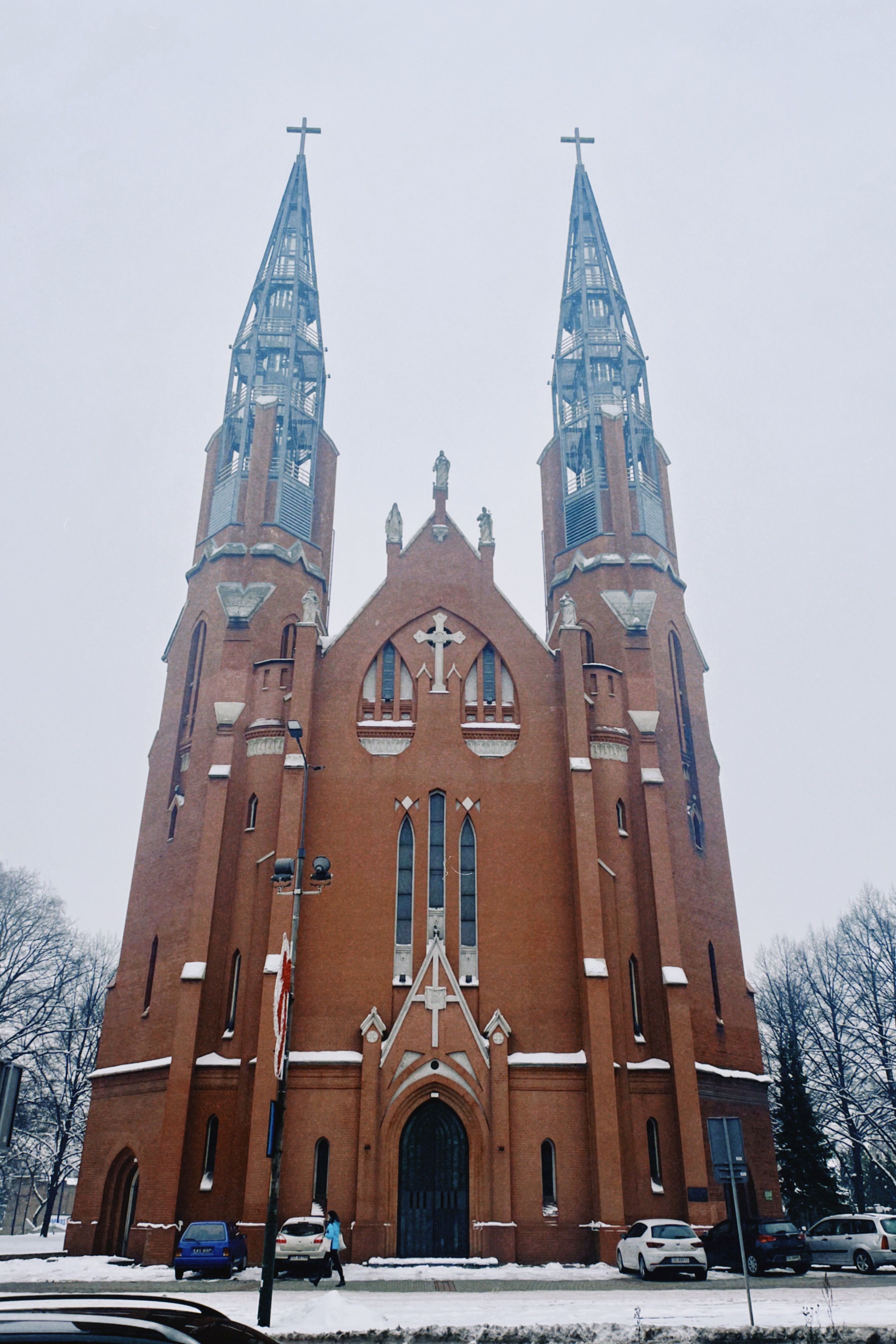 Majestic Gothic-style church in Katowice, Poland during winter snow.