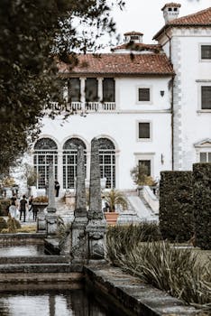 View of a historic estate with lush gardens and classic architecture in an elegant setting.