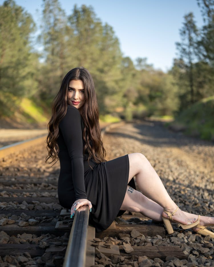 Woman Wearing Black Dress Posing On Tracks 