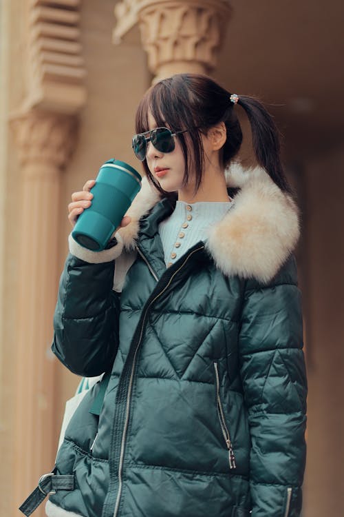 Woman Wearing Warm Coat on City Street with Coffee
