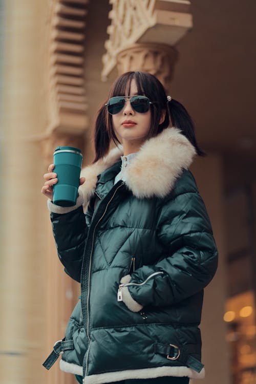 Woman Wearing Warm Coat on City Street with Coffee