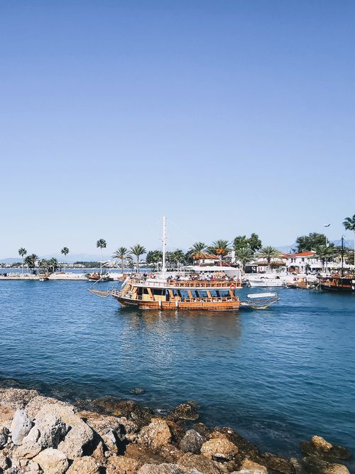 Free Scenic view of a wooden boat in a tropical harbor with a clear sky. Stock Photo