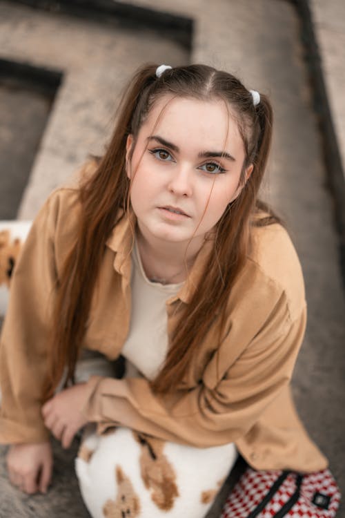 Photo of a Woman with Pigtails Sitting on Steps