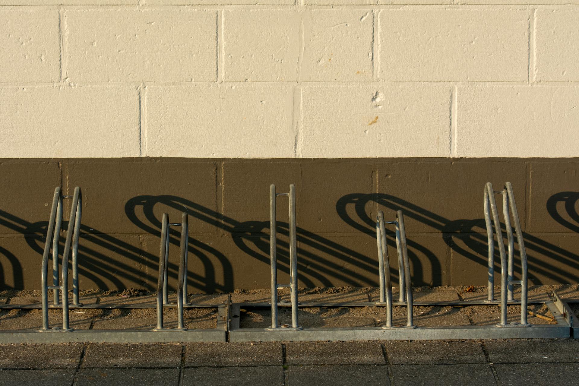 Empty Bicycle Racks by the Wall
