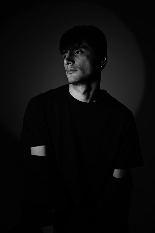Free Portrait of a pensive man in dramatic lighting, showcasing elegance and simplicity. Stock Photo