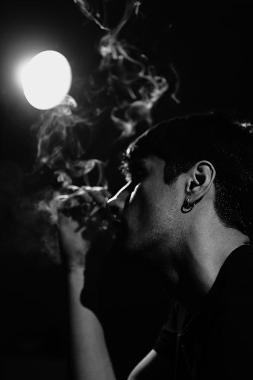 Dark Photo of a Man Smoking a Cigarette