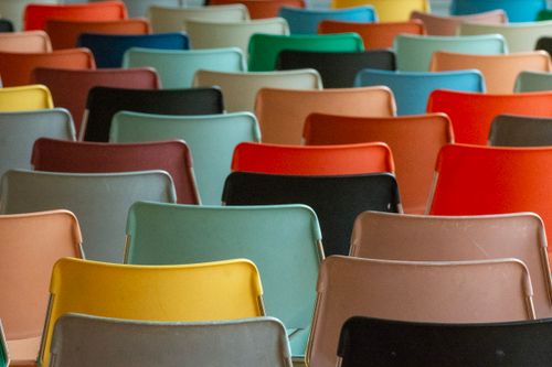 Free Vibrant and diverse assortment of colored chairs arranged in rows, focused on back view. Stock Photo