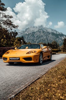 Yellow sports car on a scenic mountain road under sunny skies. Perfect blend of luxury and nature.
